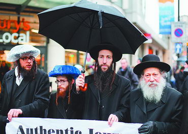 Ортодоксальные евреи выступают в поддержку антифашистского митинга возле станции метро «Холборн», Лондон. 26 января 2014 года