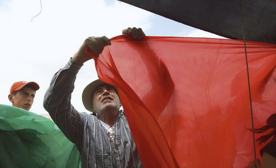 Эзра Нави вывешивает куски ткани, окрашенные в цвета палестинского флага, в знак протеста против израильских поселений на территории Хевронских холмов. Май 2010. The New York Times Agency